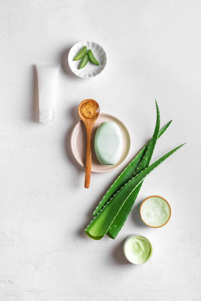 Aloe vera plant leaves, gel, skin care products on white, top view. Natural organic aloe vera cosmetics for face and body care. - Foto, afbeelding