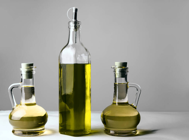 Set of vegetable or olive oil glass bottles  on isolated  background. The collection of three narrow and high bottles. - Foto, imagen