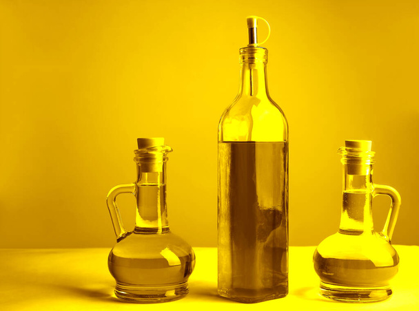 Set of vegetable or olive oil glass bottles  on isolated  background. The collection of three narrow and high bottles. - Foto, imagen
