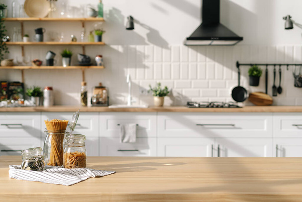 Kücheneinrichtung im skandinavischen Stil mit Dosen mit Getreide. Comfort-Umweltkonzept. Moderne weiße Möbel, Pflanzen, Geräte und Dekorationen im Hintergrund - Foto, Bild