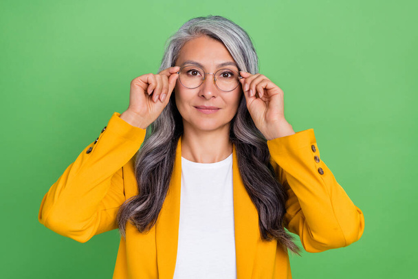 Photo of retired woman hands touch eyeglasses oculist eyesight attorney isolated over green color background - Φωτογραφία, εικόνα