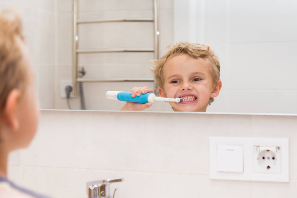 Egy ötéves fiú kezet mos a fürdőszobában. Egy ötéves, európai fiú odakint kezet mos a tükör előtt a fürdőszobában. - Fotó, kép