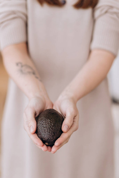 Hands holding fresh avocado. Closeup - Photo, Image