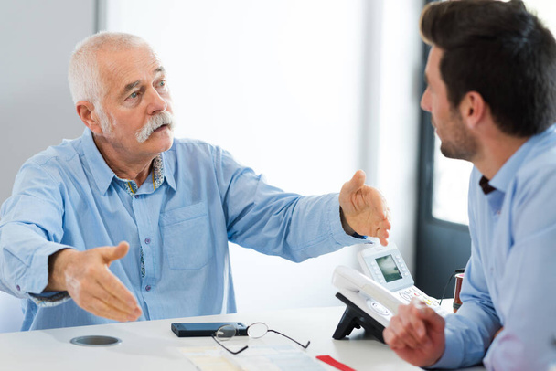senior businessman giving advice to a younger colleague - Zdjęcie, obraz