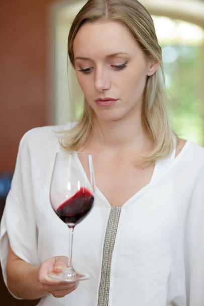 beautiful woman tasting wine while sitting in restaurant - Photo, Image
