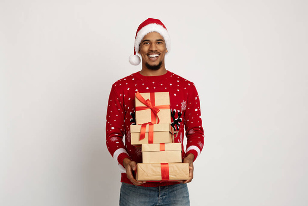 Sonriente afroamericano hombre Santa Claus sosteniendo regalos - Foto, Imagen