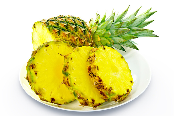 Schneiden Sie eine Ananas auf einer Platte isoliert auf weißem Hintergrund - Foto, Bild
