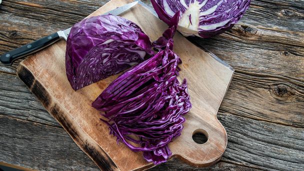 Sliced red cabbage on cutting board with knife top view - Фото, зображення