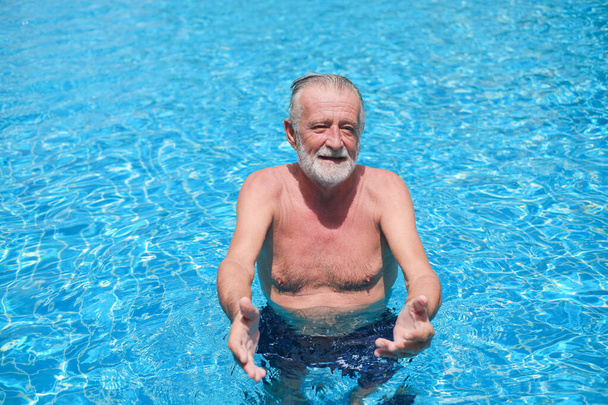 Портрет белого старика, пожилого мужчины, отдыхающего в бассейне - Фото, изображение