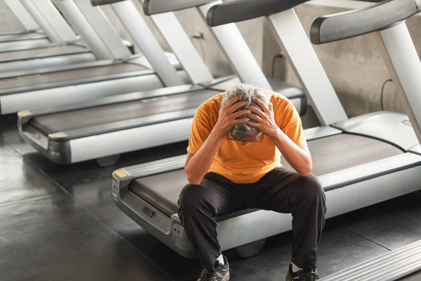 Retrato asiático sênior homem tem uma dor nas costas depois de correr esteira em fitness ginásio - Foto, Imagem