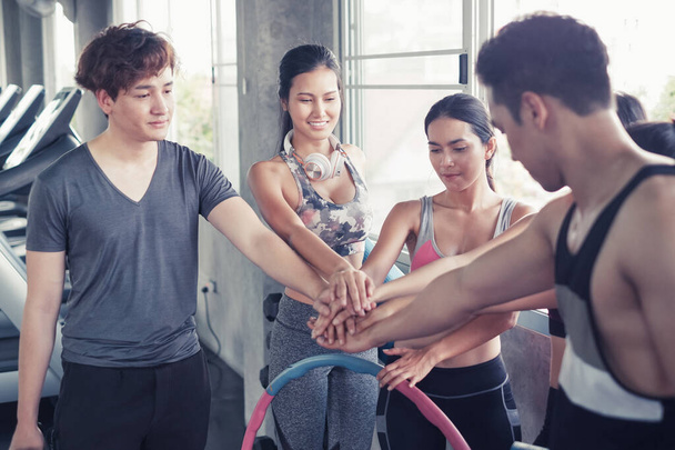 Smiling group of asian friends, happy young women and men relax together after a workout at gym center, Strength sporty and weight loss concept - Fotó, kép