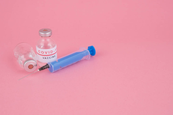 Important adjunct to protection against coronavirus (Covid-19), vaccination against coronavirus, syringe needle on a pink background - Fotoğraf, Görsel