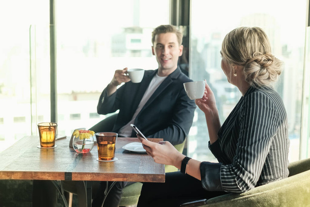 Dos hombres de negocios y una pareja de mujeres de negocios se reúnen en el espacio de co-trabajo en Sky Lounge u oficina - Foto, Imagen