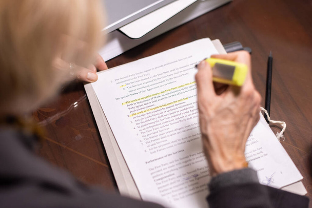 Hand of mature female lawyer highlighting main points of contract - Photo, Image