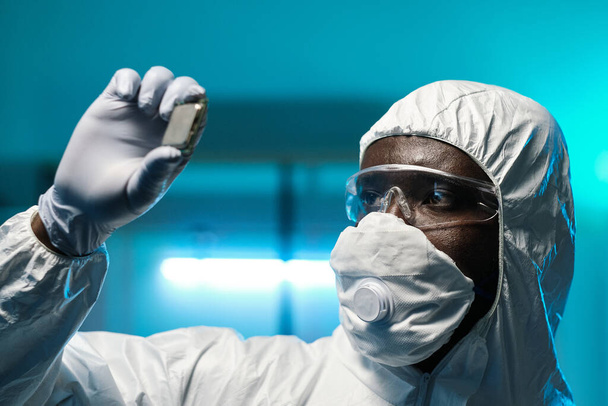 Γάντι Αφρικανός επιστήμονας σε φόρμες που κατέχουν μικροτσίπ - Φωτογραφία, εικόνα