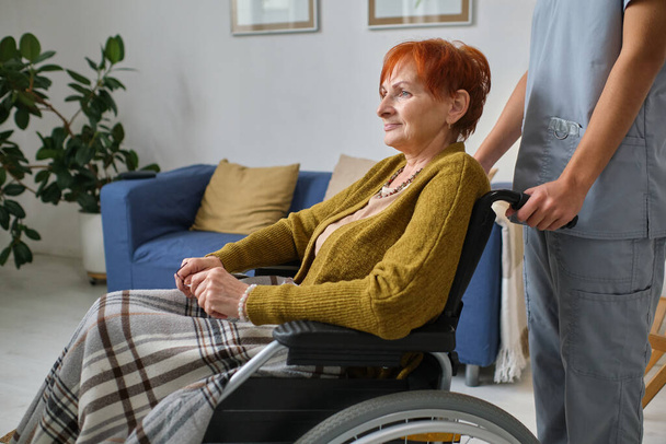 Oudere vrouw met rolstoel en verpleegster - Foto, afbeelding