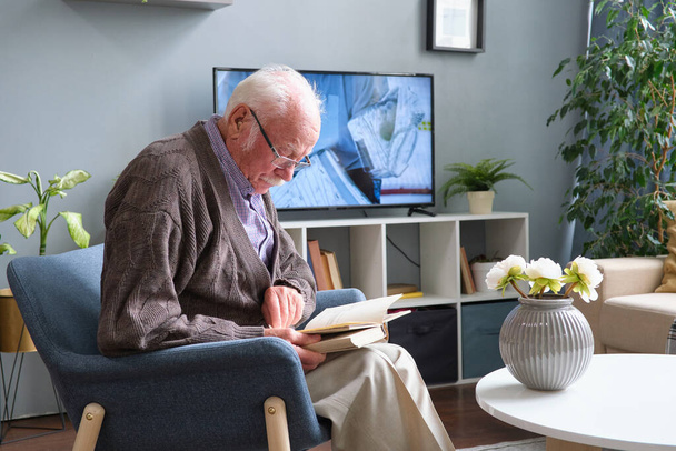 Homem sênior lendo um livro em casa - Foto, Imagem