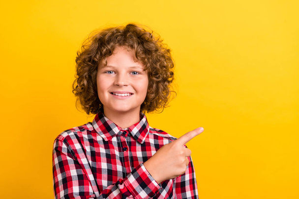 Photo of funky ginger wavy hairdo little boy index empty space wear red plaid shirt isolated on yellow color background - Fotoğraf, Görsel