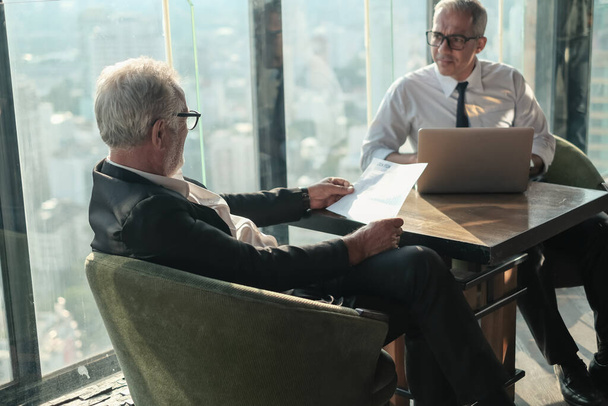 Dos personas mayores de negocios se reúnen en un espacio de trabajo compartido en un salón de rascacielos u oficina - Foto, Imagen