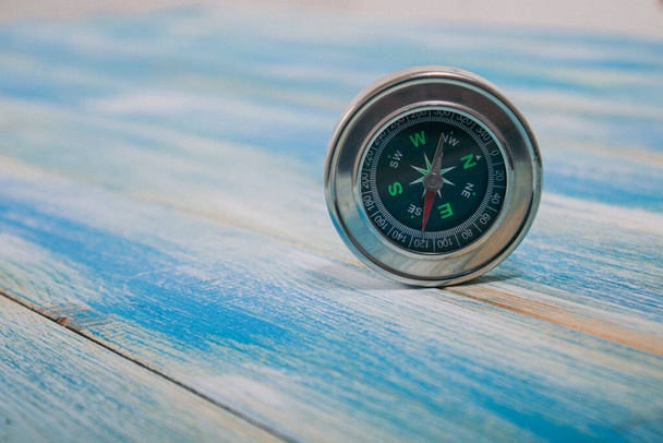 compass on a blue wooden table - Φωτογραφία, εικόνα
