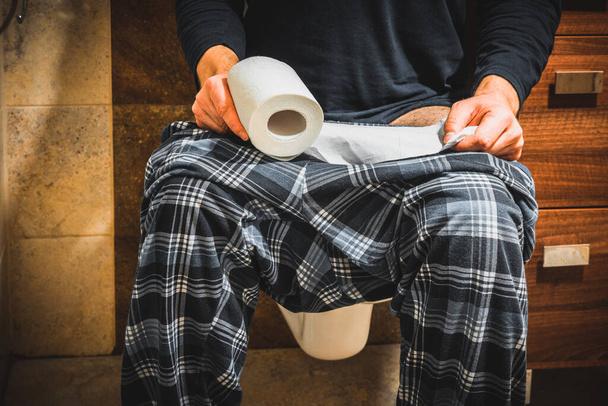 Hombre en pijama sentado en el inodoro, Concepto, Gástrico, problemas de salud  - Foto, imagen