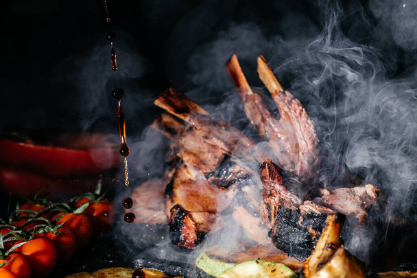 Grilled lamb ribs on the grill with smoke. Roasted Rectangle Rack of Lamb Chops. Culinary, cooking, bakery concept, - Foto, immagini