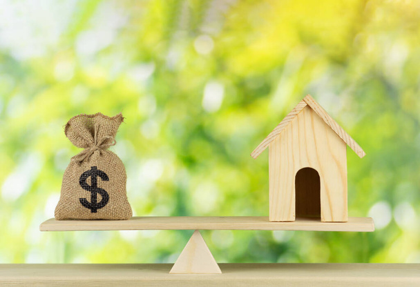 Home and money bag Us dollar sign put on the scales with balance saving for a real estate concept loan for plan business investment in the future - 写真・画像
