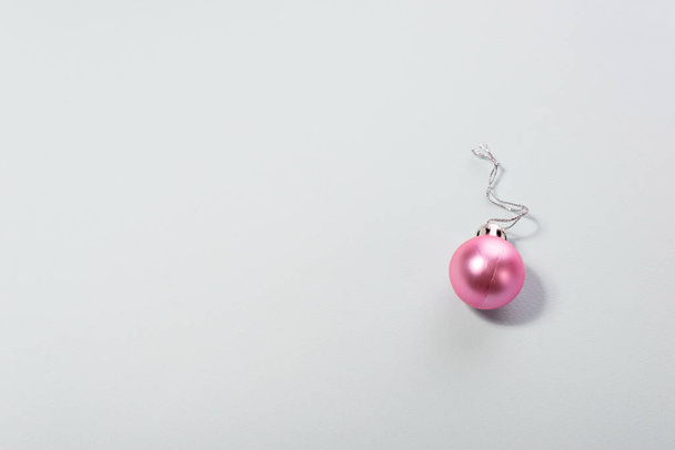 Joulun vaaleanpunainen pallo minimalismi sinisellä pohjalla. - Valokuva, kuva