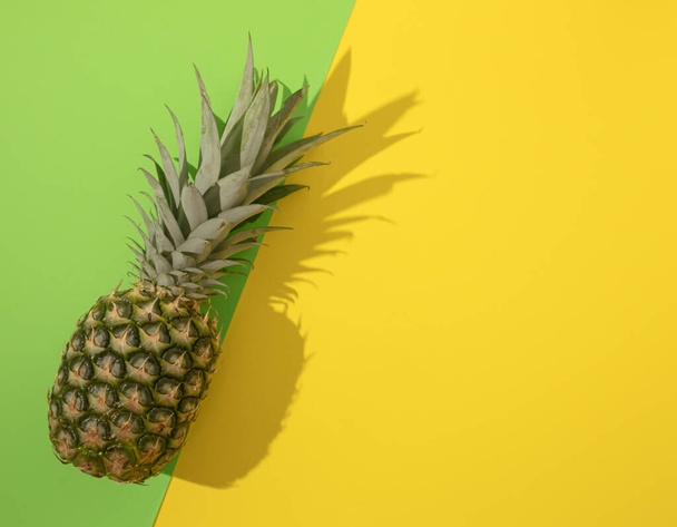 Colorful pineapple on yelow and green background. Top view. Minimal tropical fruit summer concept. - Foto, afbeelding