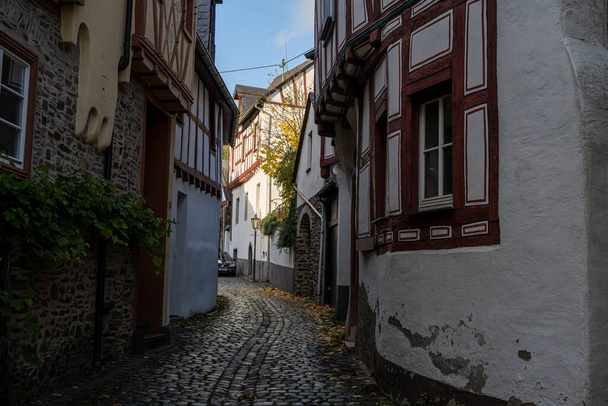 Wąska uliczka w starym miasteczku Mosel Valley w Niemczech. Piękne stare domy - Zdjęcie, obraz