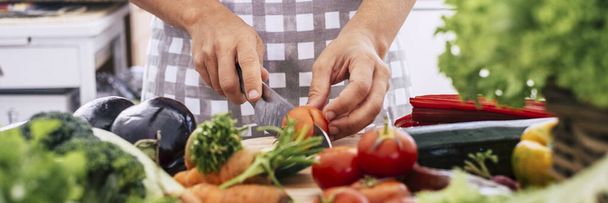 Nagłówek banerowy z kobietą krojącą warzywa na stole. Pojęcie przygotowania żywności w domu lub restauracji. - Zdjęcie, obraz