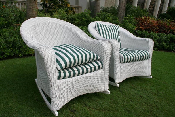 Les deux chaises en osier blanc sont sur la pelouse avant. - Photo, image