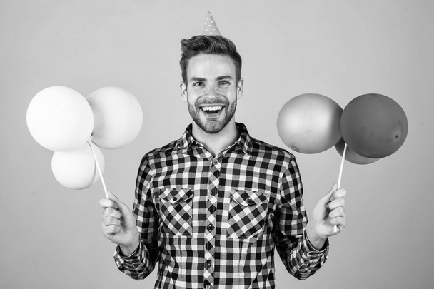 stylish guy with trendy hairstyle wear checkered shirt hold party balloons, holiday - Фото, изображение