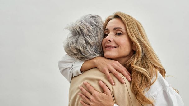 Loving grownup woman daughter embrace old mother - Photo, Image
