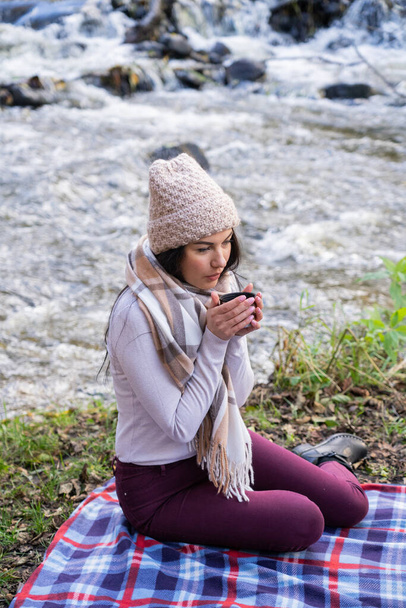 川の近くで美しい少女がお茶を飲む - 写真・画像