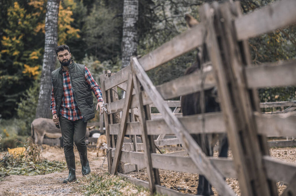 A man in plaid sgirt and a vest walking in the country side - Foto, Imagem