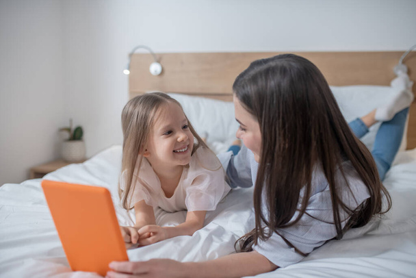 Mother with the tablet and her cheerful daughter - Foto, Bild