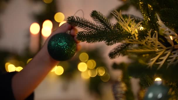 Hand van kleine jongen hangende bal op kerstboom - Video
