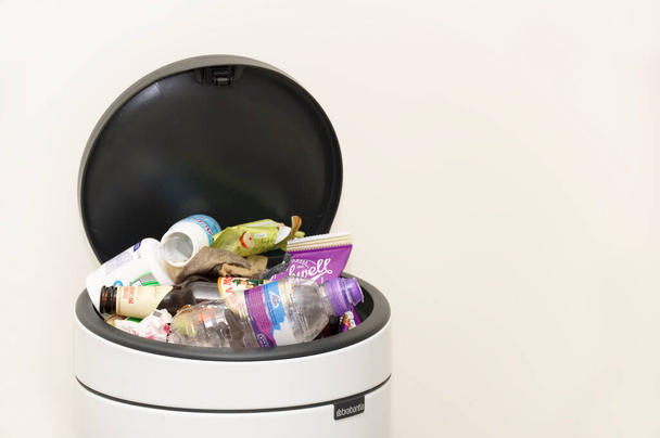 Londen, Engeland, UK, 27 februari 2021, Gemengde rommel in vuilnisbak zonder scheiding van plastic, papier en voedsel - Foto, afbeelding