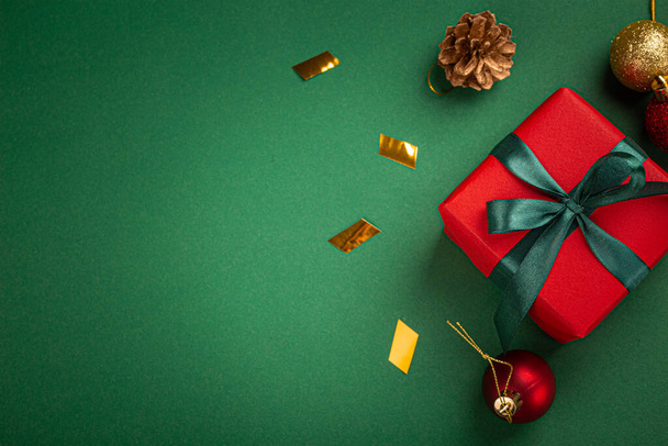 Vánoční kompozice s dárkem a dekoracemi v červené, zelené, zlaté barvě - Fotografie, Obrázek