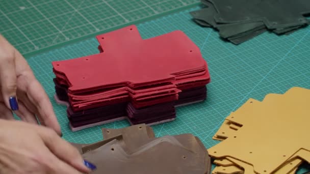 Reife weibliche Hände setzen farbenfrohe Lederdetails zusammen - Filmmaterial, Video