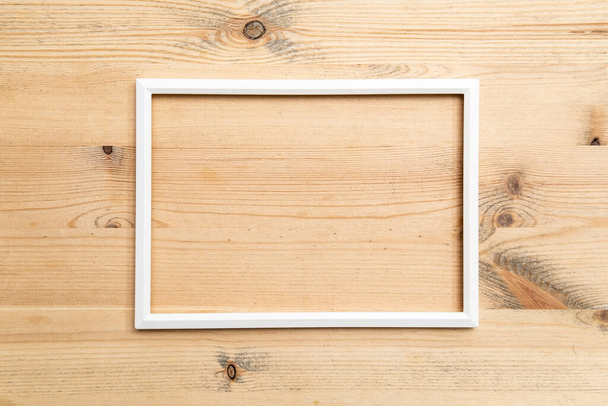 Rectangular blank white frame on wood texture. Abstract background. Copy space. Top view. - Фото, зображення