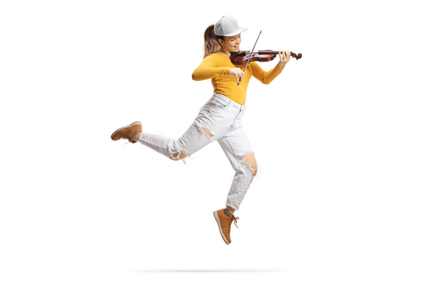 Full length shot of a modern female artist dancing and playing a violin isolated on white background  - Φωτογραφία, εικόνα