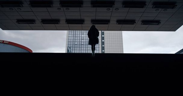 Silhouette Mädchen zu Fuß Treppe in dunklen U-Bahn-Station in der Stadt.  - Foto, Bild