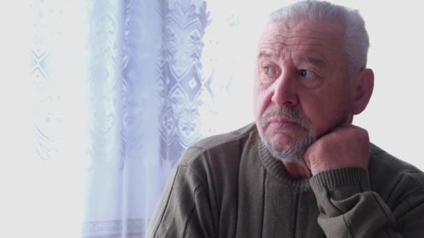 Preocupado anciano anciano anciano hombre de 80 años se sienta solo en casa . - Metraje, vídeo