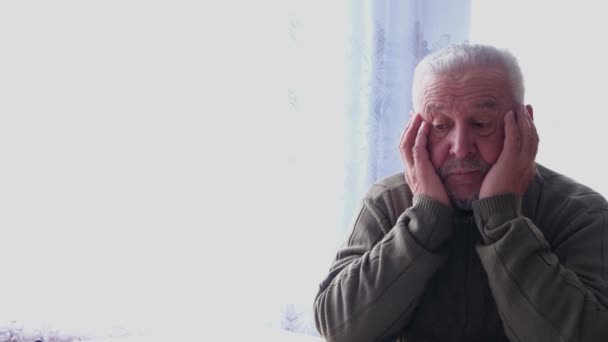 Upset senior retiree, grandfather, sitting alone on sofa at home. - Footage, Video