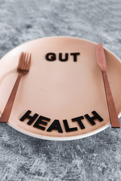 gut health text on dining plate with fork and knife, healthy nutrition and scientific research about the microbiome	 - Fotoğraf, Görsel