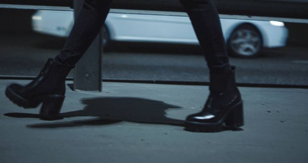 Жінка ноги йдуть шосе в пізню ніч темної дороги з проїжджаючими машинами
.  - Фото, зображення