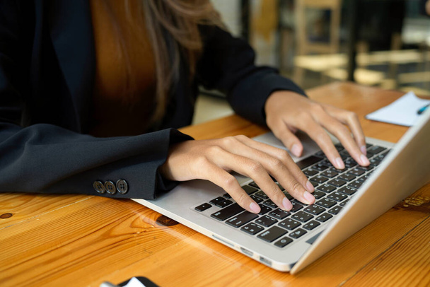 Κοντινή εικόνα μιας εργαζόμενης γυναίκας που χρησιμοποιεί φορητό υπολογιστή. Επιχειρηματίας που εργάζεται σε υπολογιστή σημειωματάριο. - Φωτογραφία, εικόνα