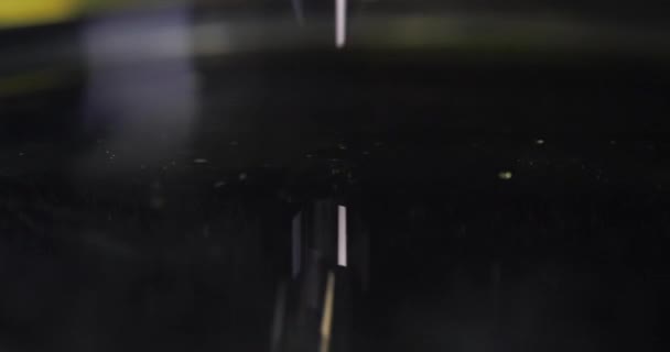 Liquide huileux jaune goutte à goutte dans le film 4k de ralenti liquide noir - Séquence, vidéo